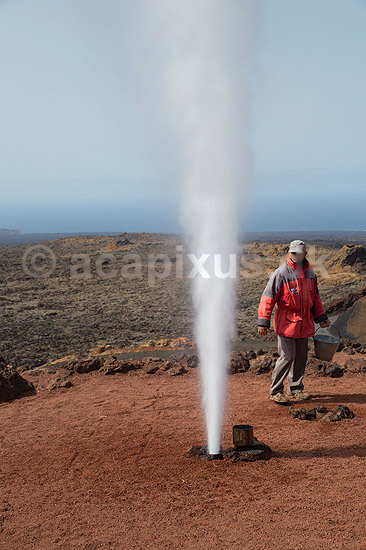 Lanzarote. Parkranger demonstrerer varmen i undergrunden ved at h�lde koldt vand i boret hul. Det kogende vand springer efterf�lgende som en geiser. Timanfaya Nationalparken p� Lanzarote i De Kanariske �er; ; Parque Nacional de Timanfaya / Lanzarote; Spanien; ; ; Vulkaner, vulkanisme, vulkan, lava, turister, turisme, charterturister