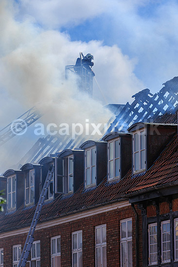 Husbrand. Brandslukker i r�gdragt slukker tagbrand i gammelt hus i Skolegade i Ribe; ; Ribe; Danmark; ; ; Brand, ildebrand, brandslukning, forsikring, brandforsikring