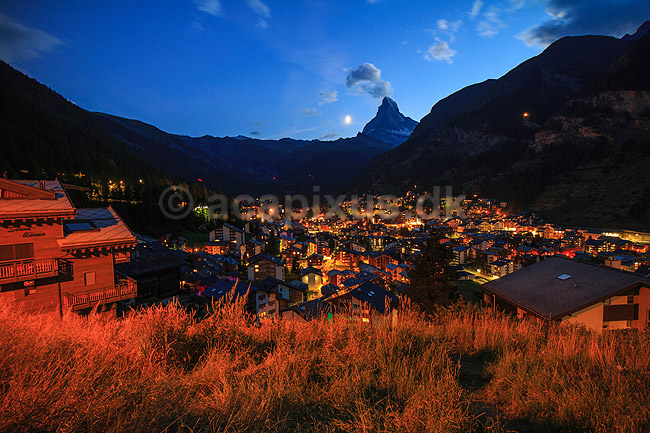 Matterhorn og Zermatt. Zermatt og Matterhorn i skumringen med m�nen p� vej til at g� ned bag bjerget; ; Zermatt; Schweiz; ; ; Alperne, bjerglandskab, Alpelandskab