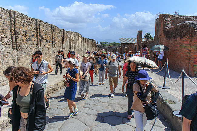 Pompeji. Turister p� Via dell Abbondanza i Pompeji; ; Pompeji / Pompei / Pompeii / Napoli / Campania; Italien; ; ; Ark�ologi, vulkaner, vulkanudbrud, pyroplastisk flow, pyroplasma, Vesuvius, Vesuv, naturkatastrofer, turistsev�rdigheder, sev�rdigheder, turisme, Romerriget, romerne, ruiner, ruinbyer